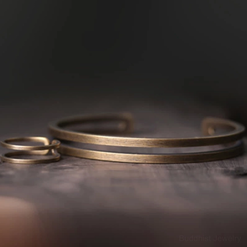 Copper cuff bracelet set with matching thin rings displayed on dark surface for spiritual jewelry