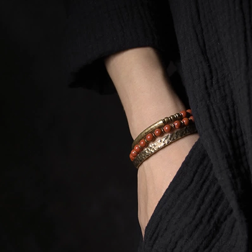 Stacked bracelet combination with hammered copper cuff and orange beaded bracelets for multiple energy layering effect
