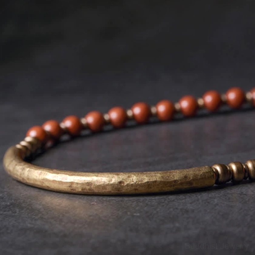 Close-up detail of hammered copper cuff texture with red jasper beads - handcrafted couple bracelet macro shot