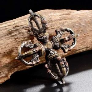 Handcrafted copper double dorje vajra overhead view on weathered wood - Buddhist thunderbolt symbol for spiritual power