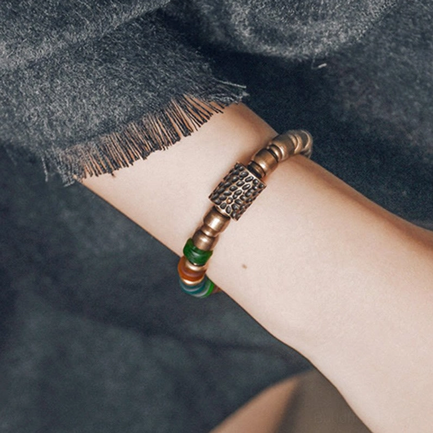 Copper and colorful glass bead bracelet worn on wrist side view with hammered metal accent bead detail