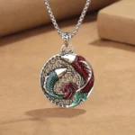 Copper koi fish Buddhist pendant necklace with red-green enamel double koi design and silver pearl chain on kraft paper