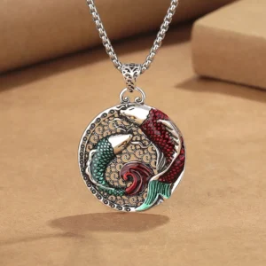 Copper koi fish Buddhist pendant necklace with red-green enamel double koi design and silver pearl chain on kraft paper