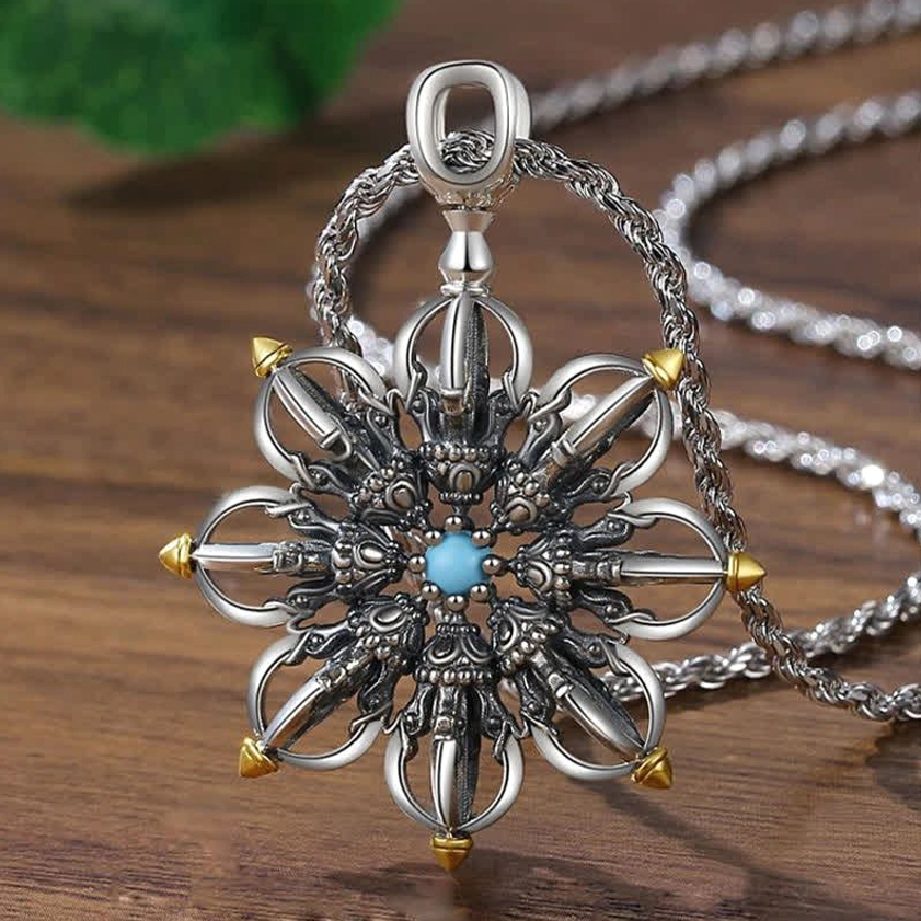 Copper lotus pendant necklace with silver finish and intricate carved details, overhead close-up view on wooden surface