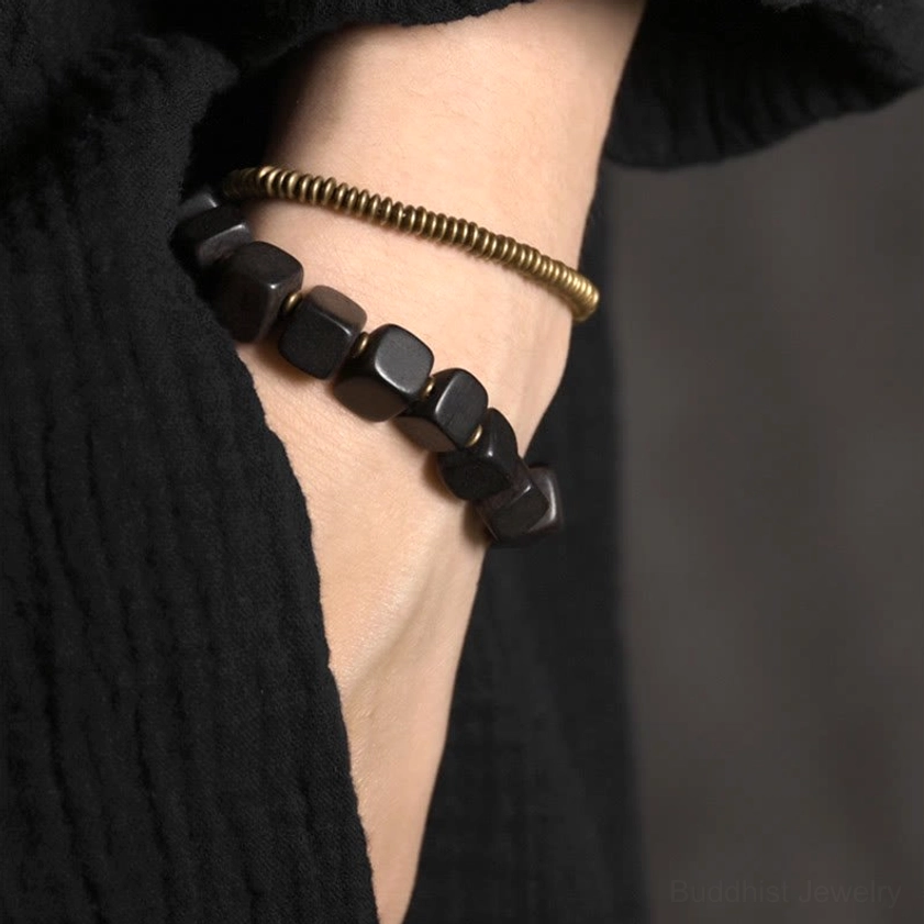 Brass copper coil metal accents with ebony wood beads in extreme close-up highlighting material composition and shine
