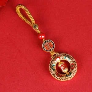 Copper prayer wheel keychain with Five Directions Gods of Wealth design, gold enamel detailing, red braided rope lanyard