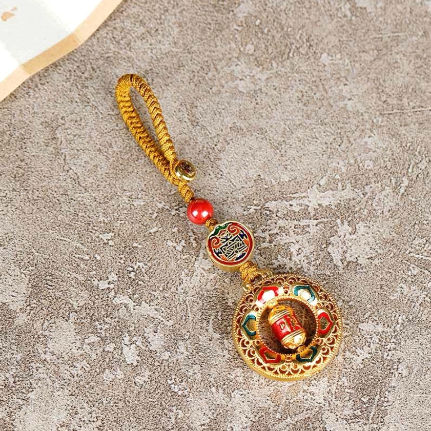 Buddhist charm prayer wheel keychain side view, compact spiritual pendant design with braided hanging string