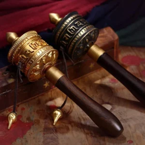 Handmade copper Buddhist prayer wheel with Om Mani Padme Hum mantra, side view showing dual-tone metal finish and wooden handle