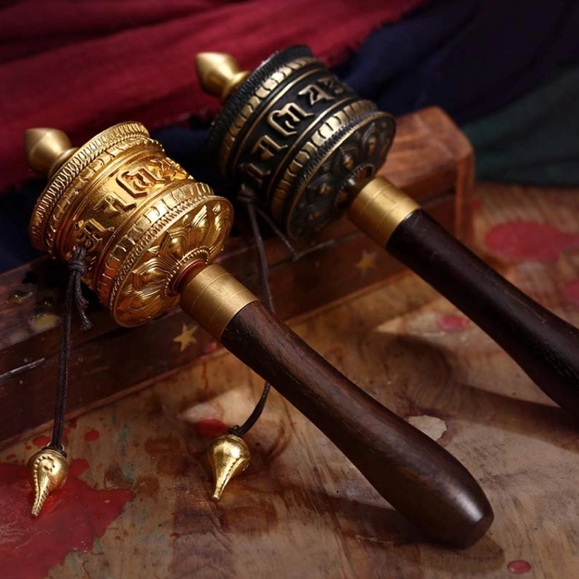 Handmade copper Buddhist prayer wheel with Om Mani Padme Hum mantra, side view showing dual-tone metal finish and wooden handle