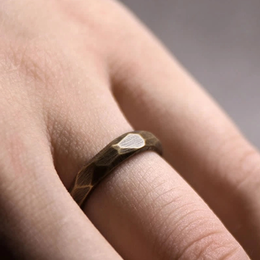 Wide copper prosperity ring 10mm band worn on index finger displaying textured Buddhist design