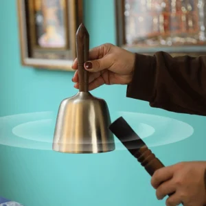 Handcrafted copper singing bowl with wooden mallet striker, hand-held demonstration with sound vibration effect