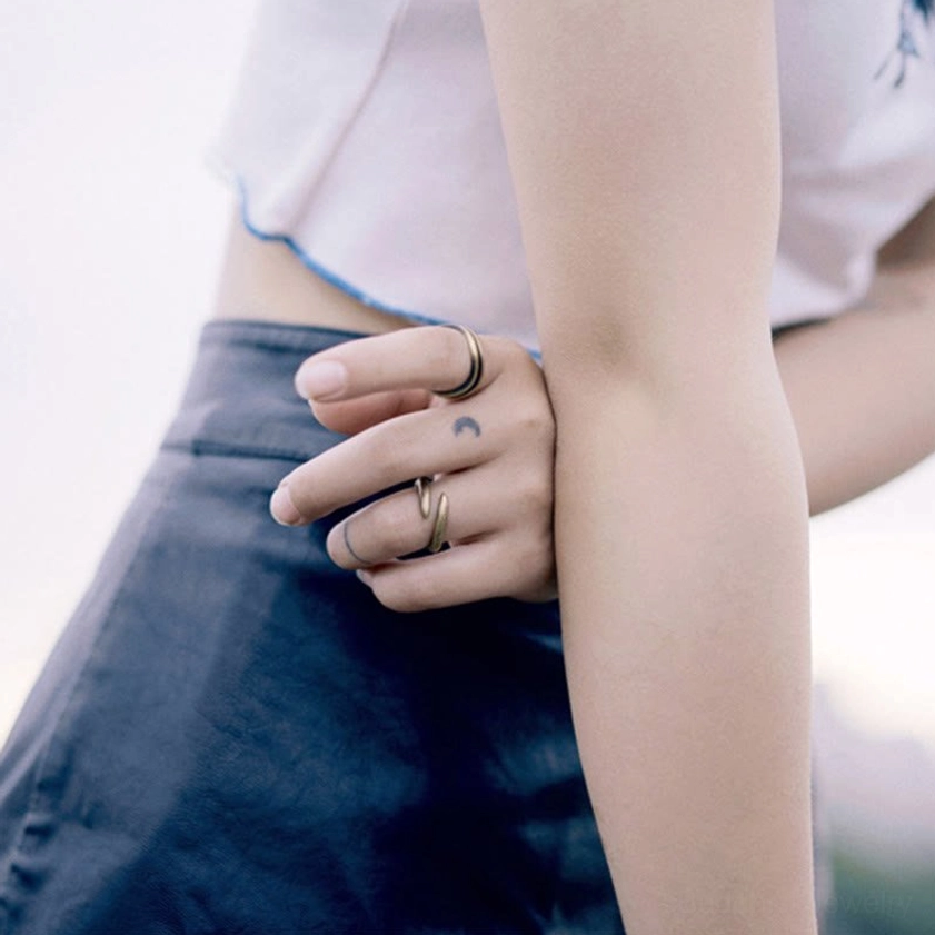 Spiral copper rings on fingers back angle view, casual outfit scene, handcrafted jewelry