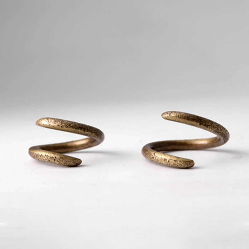 Two matching copper spiral rings flat lay, antique gold finish, identical wrap design