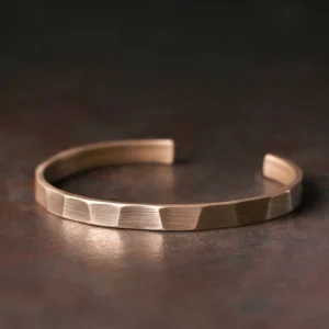 Vintage copper wealth cuff bracelet women's size 55mm flat lay with faceted brushed finish on rustic brown background
