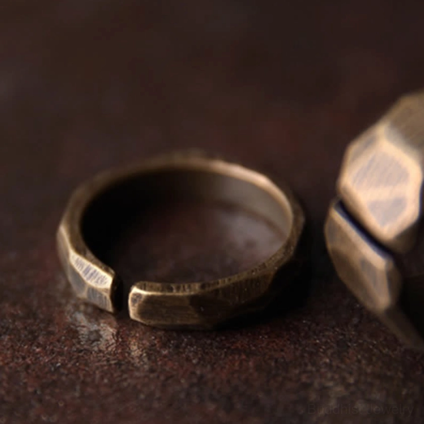 Two adjustable copper wealth rings shown in oblique view highlighting open clasp mechanism