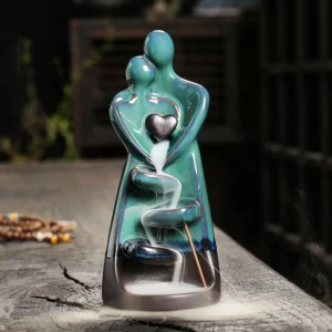 Couple embrace turquoise ceramic backflow incense burner with flowing smoke effect on wooden table