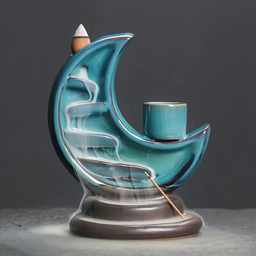 Crescent moon ceramic backflow incense burner with flowing teal smoke, handcrafted meditation burner with dark brown base