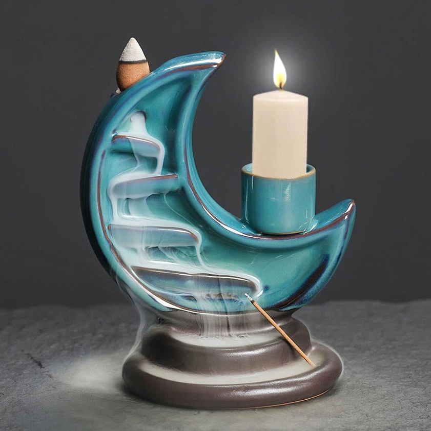 Front center view of teal crescent moon incense burner with dark brown base and lit candle, smoke effect