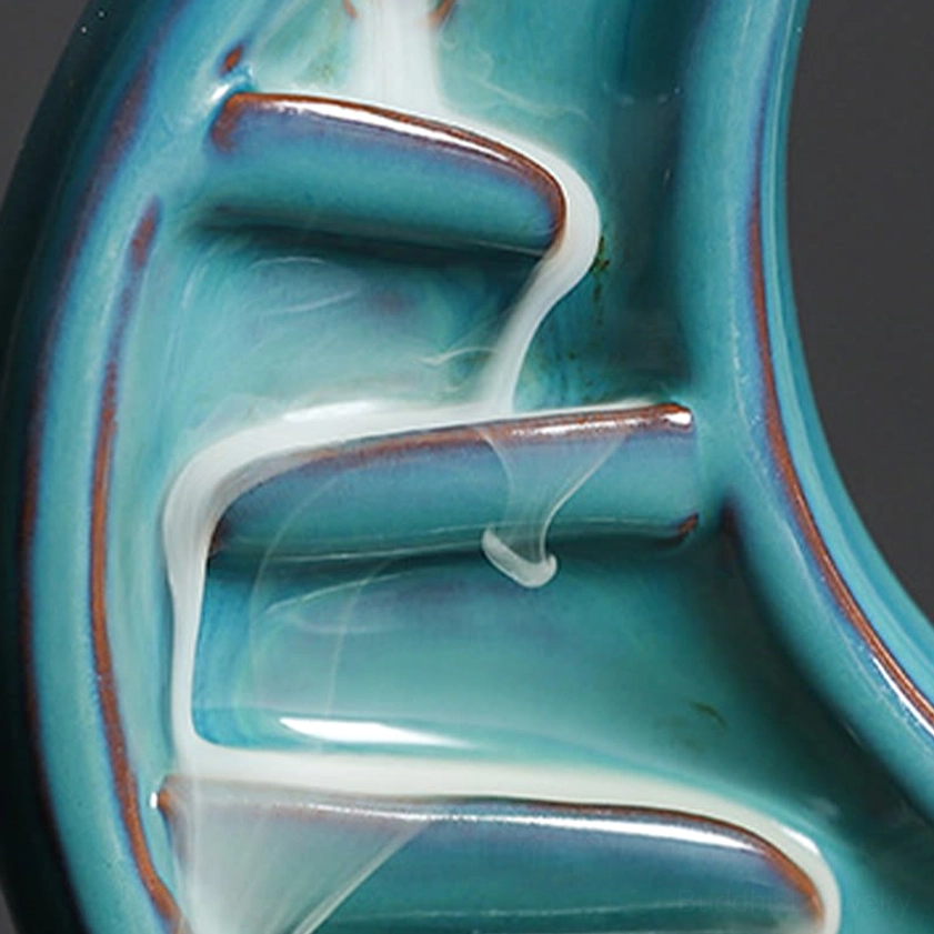 Crescent moon backflow incense burner with flowing teal smoke and lit candle, mindfulness meditation