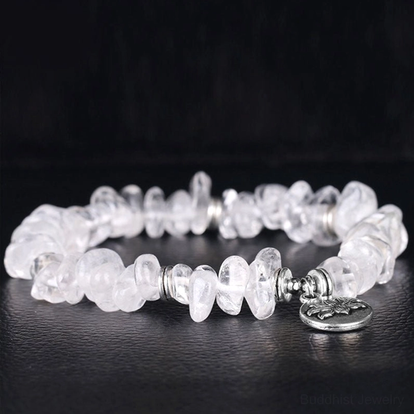 White crystal lotus bracelet side flat lay showing lotus charm detail and silver hardware