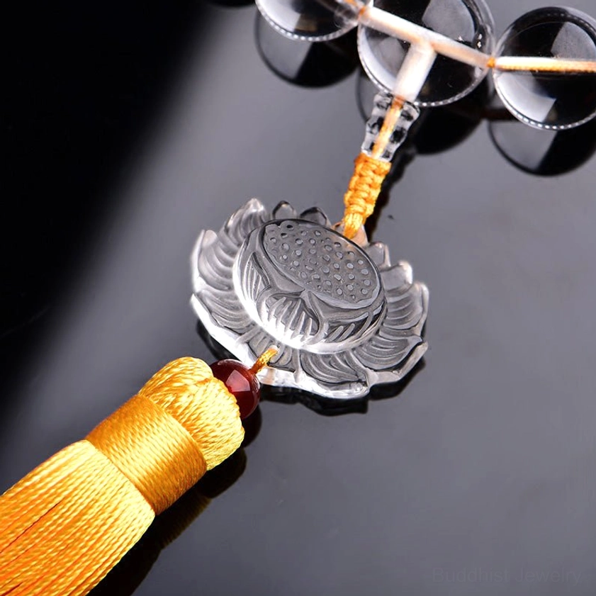 Crystal lotus tassel accessory in close-up, displaying hand-carved lotus detail and woven yellow tassel