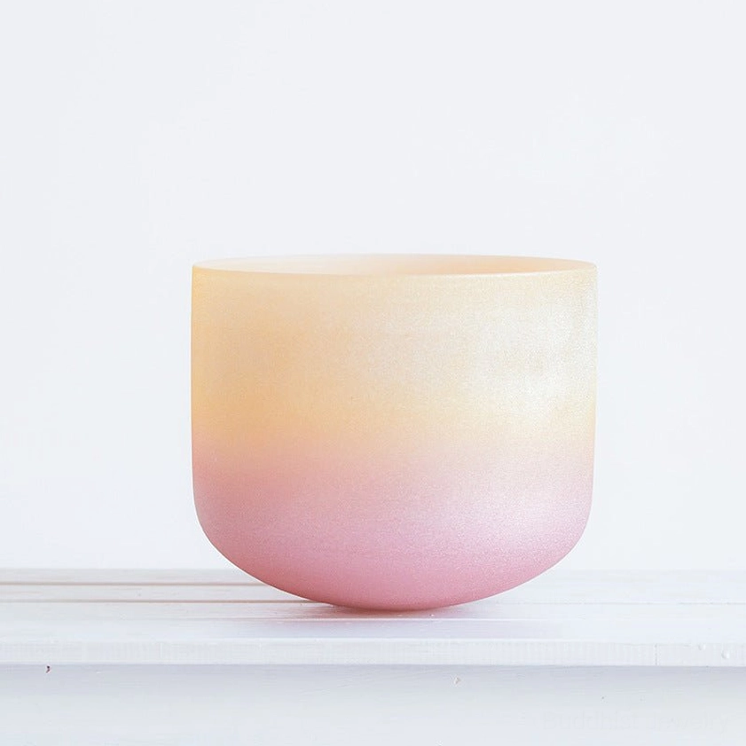 Handcrafted white crystal singing bowl with yellow-to-pink ombre gradient finish, front view on white background, ideal for meditation and chakra healing