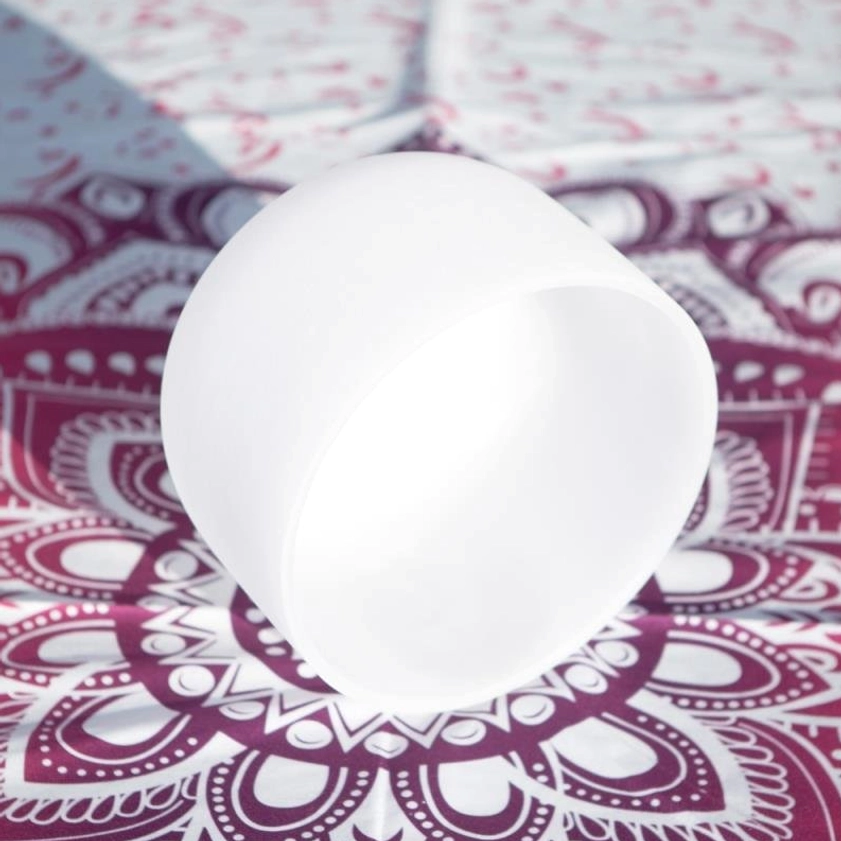 Overhead view of white frosted crystal singing bowl showing open bowl shape and translucent texture on mandala patterned surface