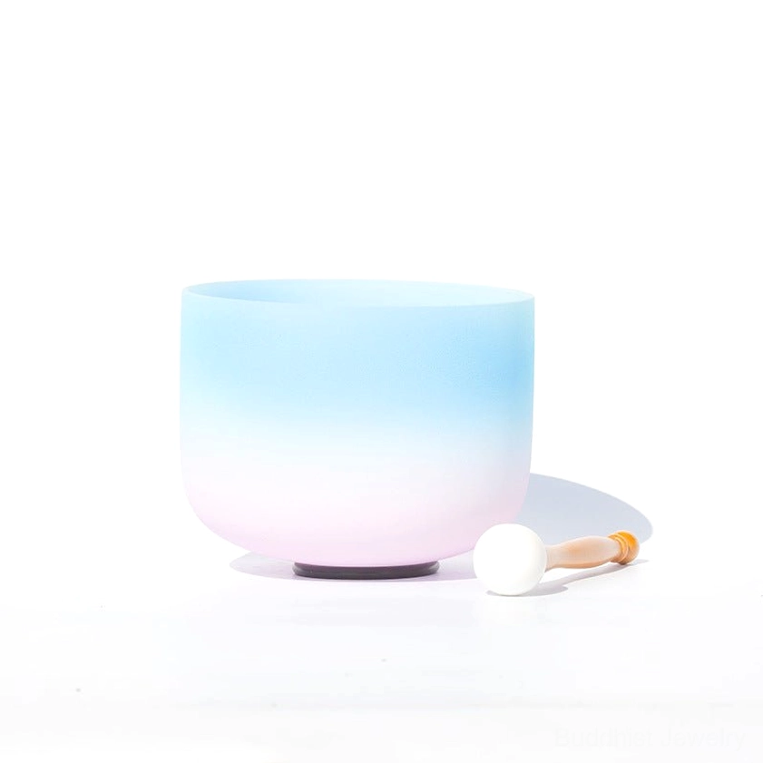 Side front view of white crystal singing bowl with blue-pink ombre matte finish and black rubber base with wooden striker