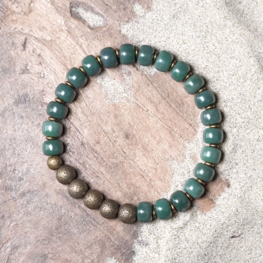 Cyan bodhi seed bracelet top-down flat lay featuring all round matte cyan beads on sand texture