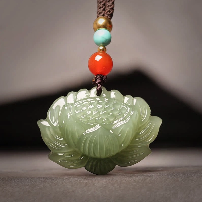 Hetian cyan jade lotus flower pendant necklace with multi-color beaded rope, flat lay front view on dark background showing carved 3D lotus design
