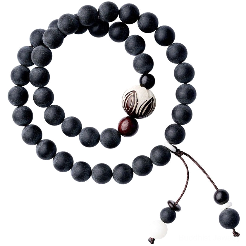 Double-layer meditation bracelet featuring carved white lotus bodhi bead with red accent bead and decorative tassel on wooden surface