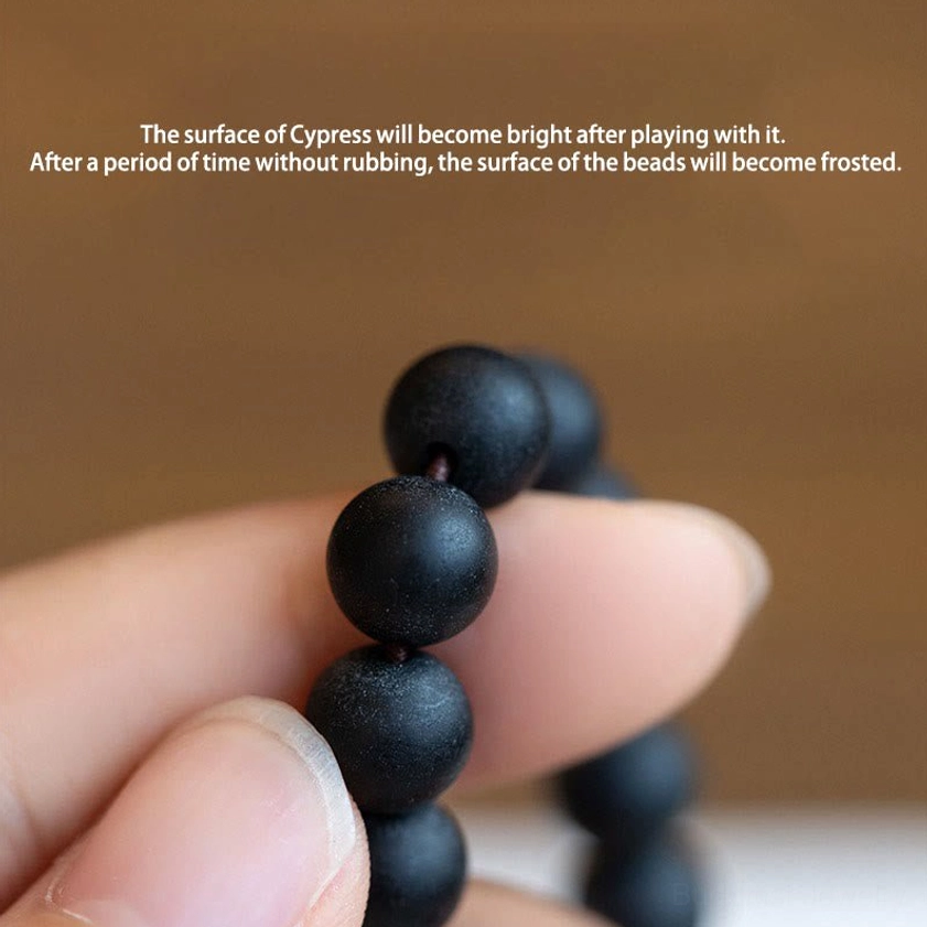 Cypress wood prayer beads with frosted matte bead surface held in hand showing natural texture and craftsmanship