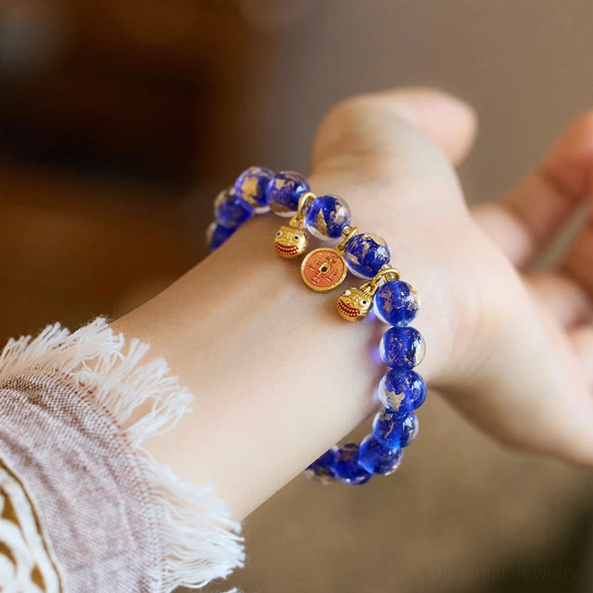 Dark blue liuli glass bead feng shui prosperity bracelet featuring gold swallowing beast charm and copper coins