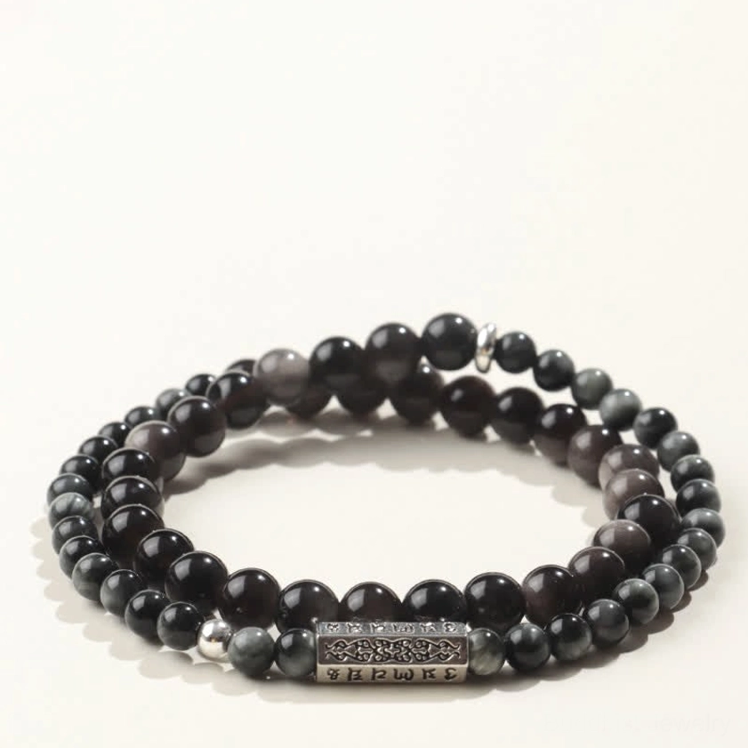 Flat lay photograph of solid dark obsidian and grey beaded double wrap bracelet with silver Om Mani Padme Hum engraved charm, Buddhist spiritual jewelry