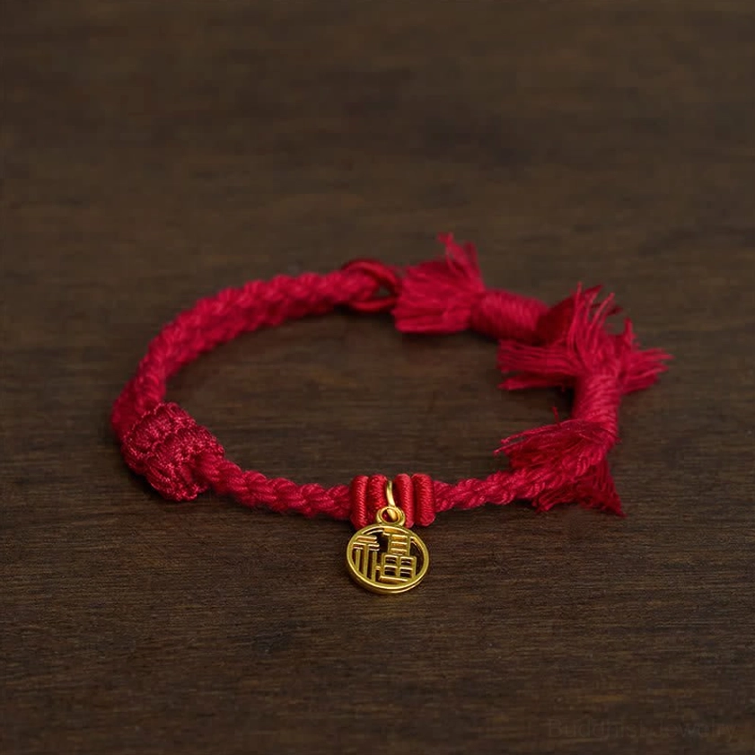 Dark red fu character bracelet angled view displaying cord knots and gold fu pendant craftsmanship