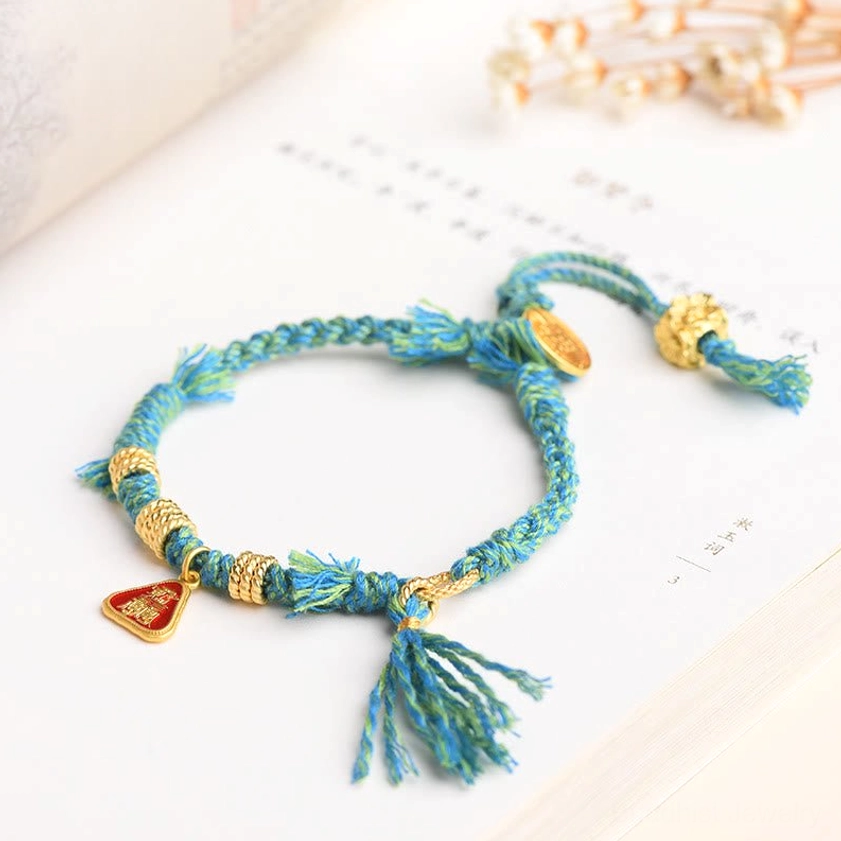 Dark red string protection bracelet featuring ancient goddess figure, flower tassel decoration, and copper metal accents handcrafted