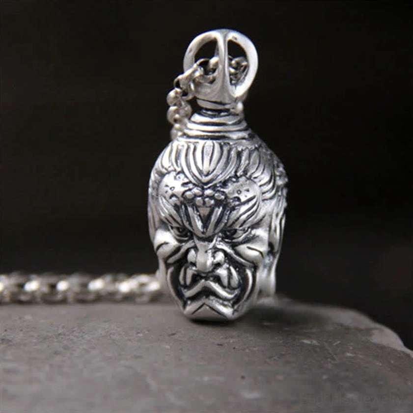Demon guardian head silver pendant close-up front view, fierce protective expression with aged patina finish