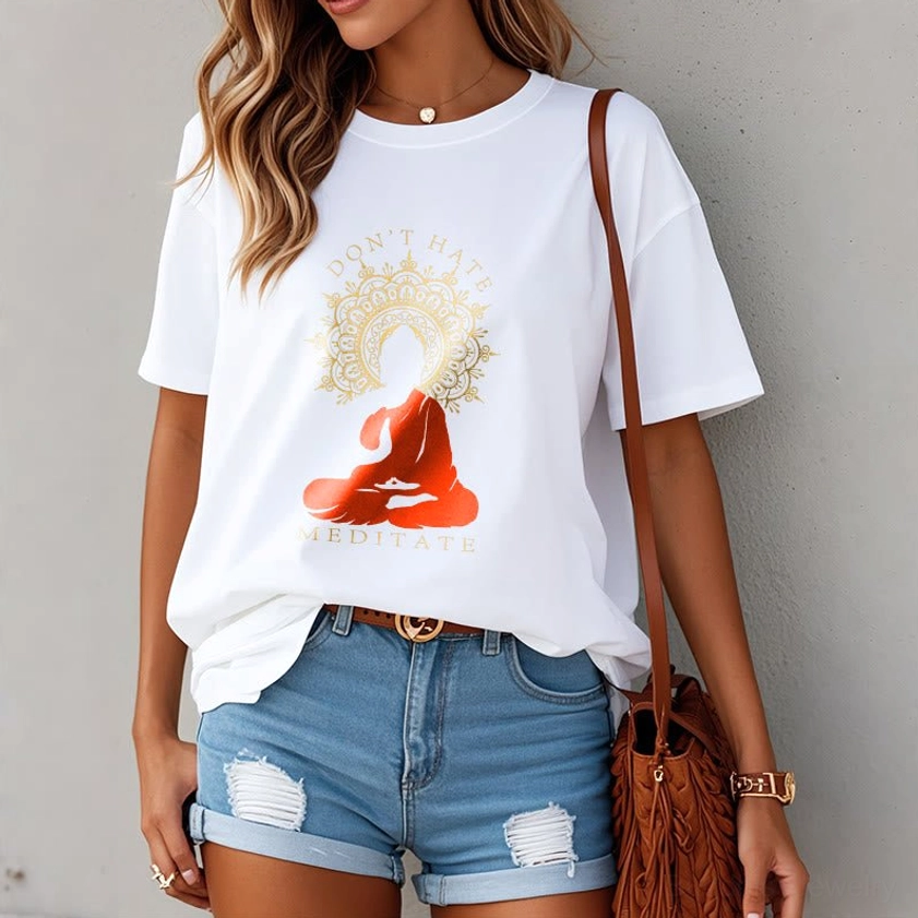 Female model wearing white Don't Hate Meditate graphic t-shirt with ripped denim shorts