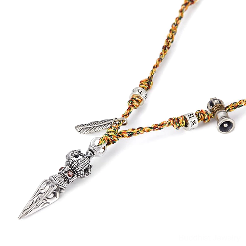 Angled Flat Lay of Sterling Silver Dorje Pendant with Detailed Vintage Silver Craftsmanship, Woven Rope, and Sacred Bead Accents