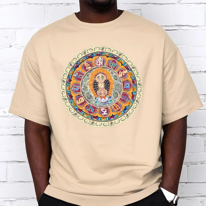 Male model wearing beige Dorje Vajra Mandala Buddhist cotton t-shirt with colorful mandala artwork, casual styling against white brick wall