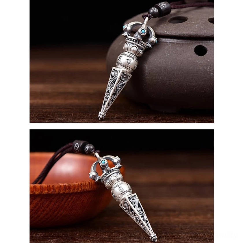 Close-up side view of miniature Dorje Vajra Buddhist pendant with silver retro texture displayed with ceramic incense burner
