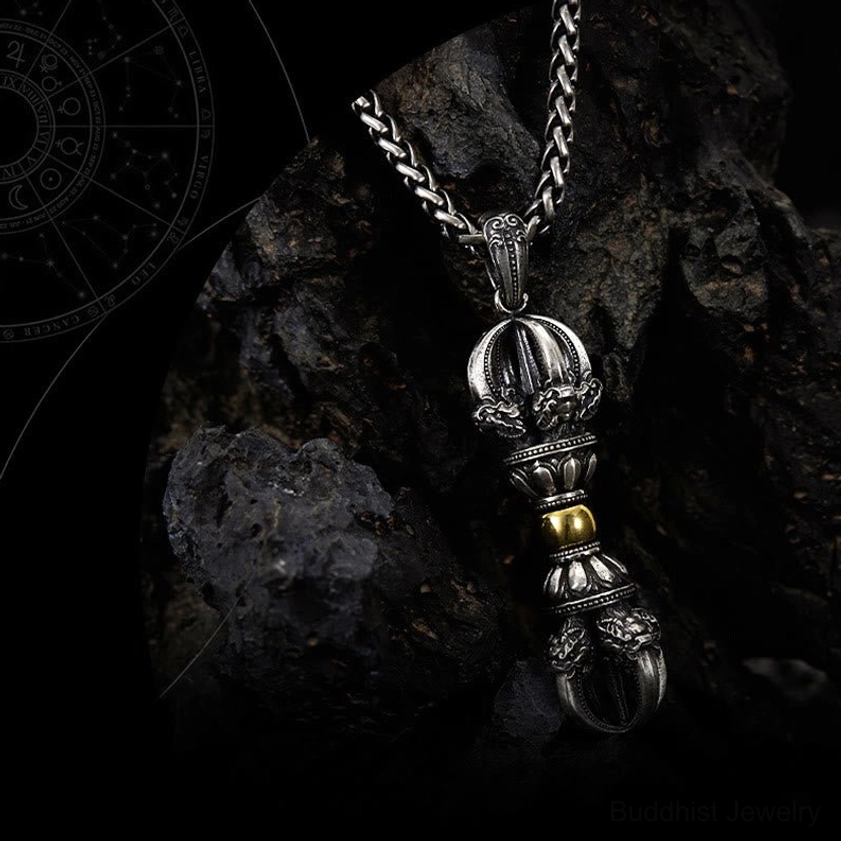 Close-up side view of dorje vajra pendant with intricate carved texture and central gold bead detail
