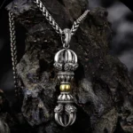 Dorje vajra copper pendant necklace front oblique view with vintage silver and gold details on dark rock backdrop