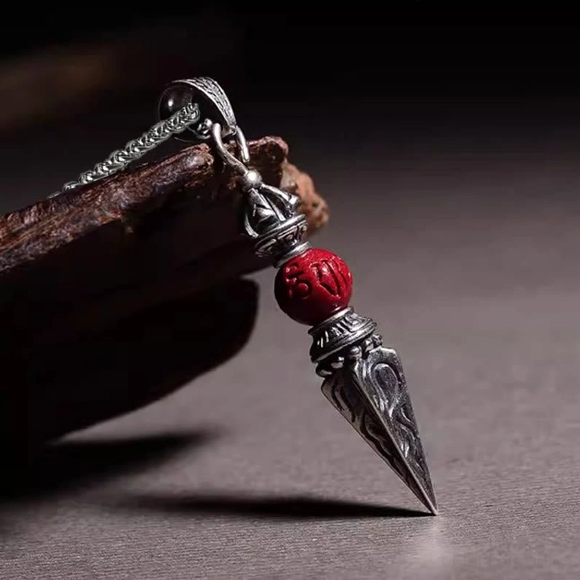 Dorje Vajra cinnabar pendant necklace side angle view on wooden display prop