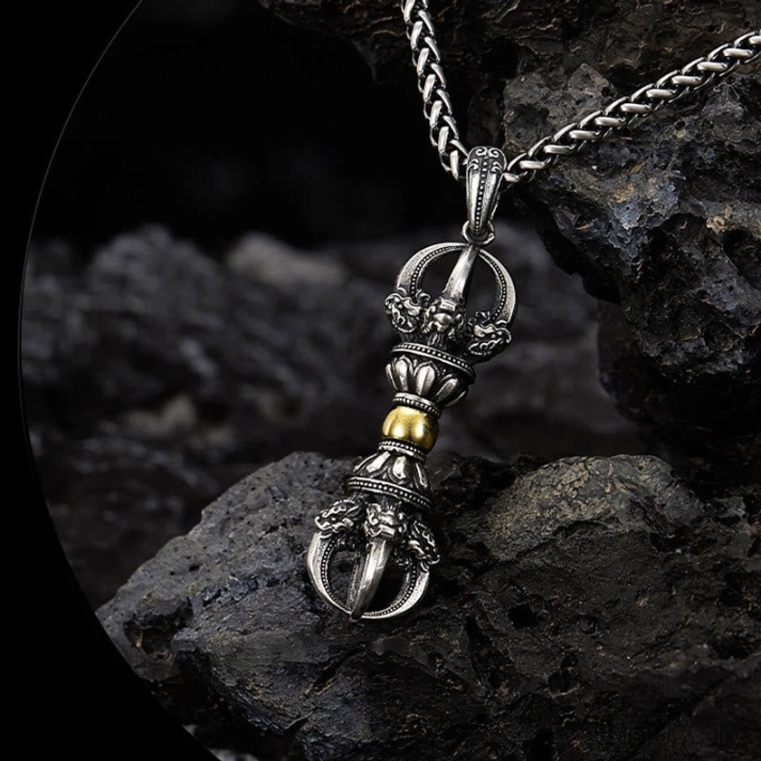Buddhist dorje vajra necklace top-down close-up showing dual-tone metal and pronged vajra terminal design