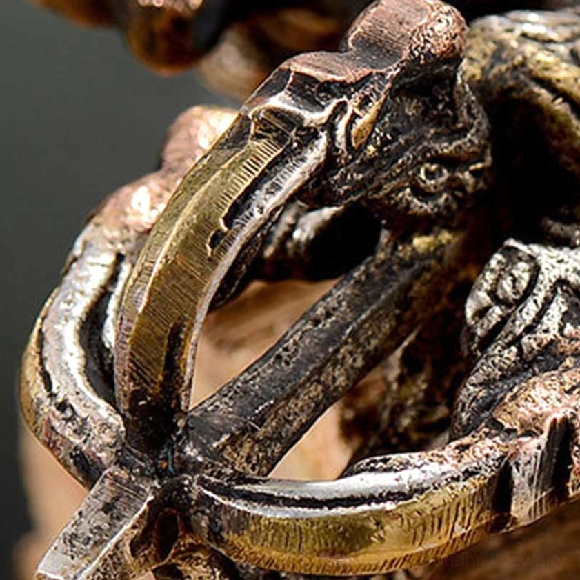 Macro detail of double dorje vajra prong with thick metal bands and intricate relief patterns showing handcrafted quality