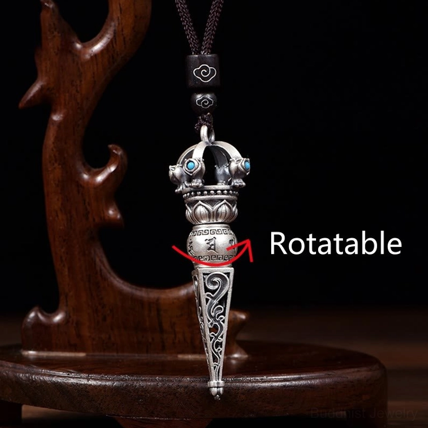 Rotatable Dorje Vajra Buddhist pendant necklace on wooden display stand with black woven necklace cord