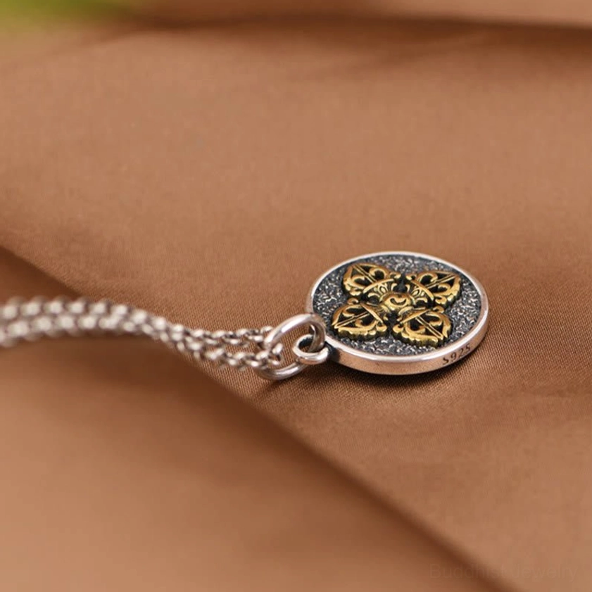 Double dorje vajra pendant necklace low side angle view showing silver cable chain
