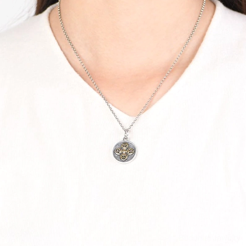 Double dorje vajra necklace worn close-up showing delicate chain and pendant on white clothing
