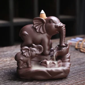 Double elephant purple clay backflow incense burner with smoke flowing through trunk into lotus tray, front-left view